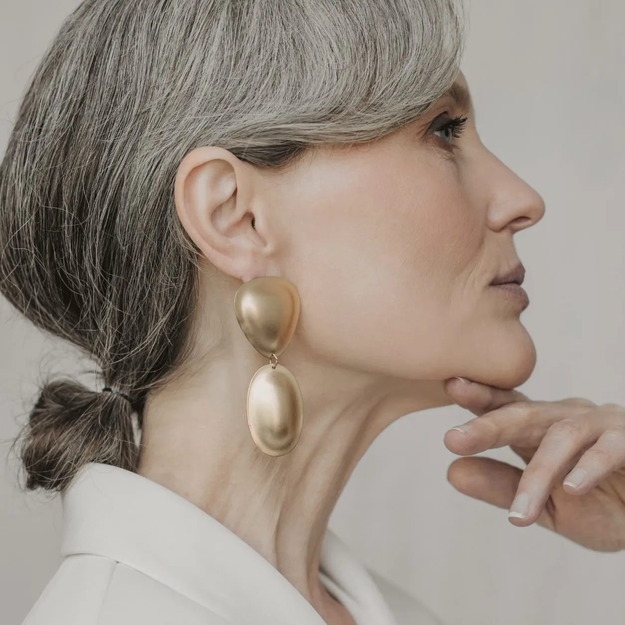 Perfil de una mujer madura con la mano bajo la mandíbula, que muestra la línea del rostro