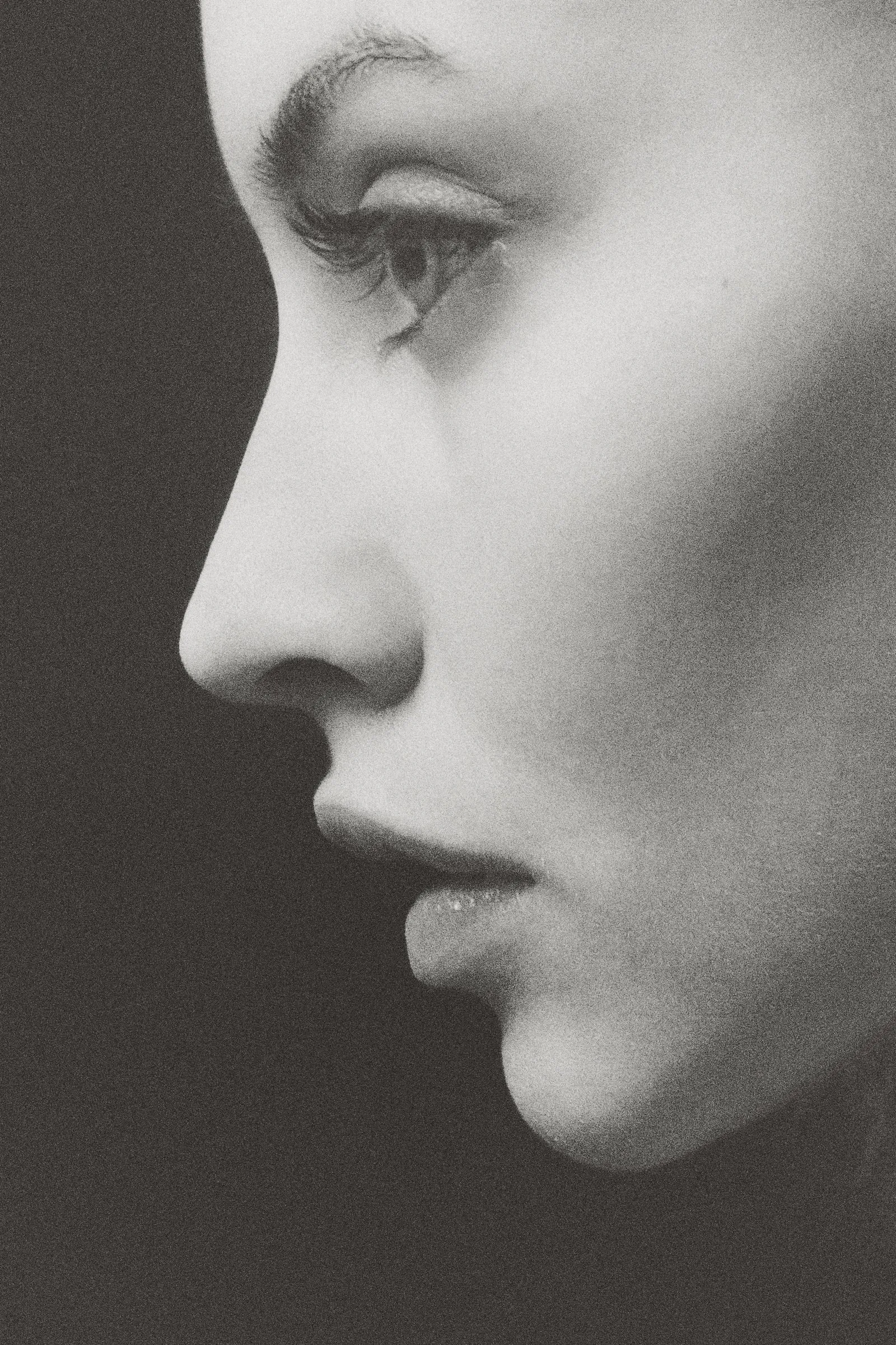 Perfil de una mujer en blanco y negro, con la piel luminosa, la nariz y los labios en primer plano